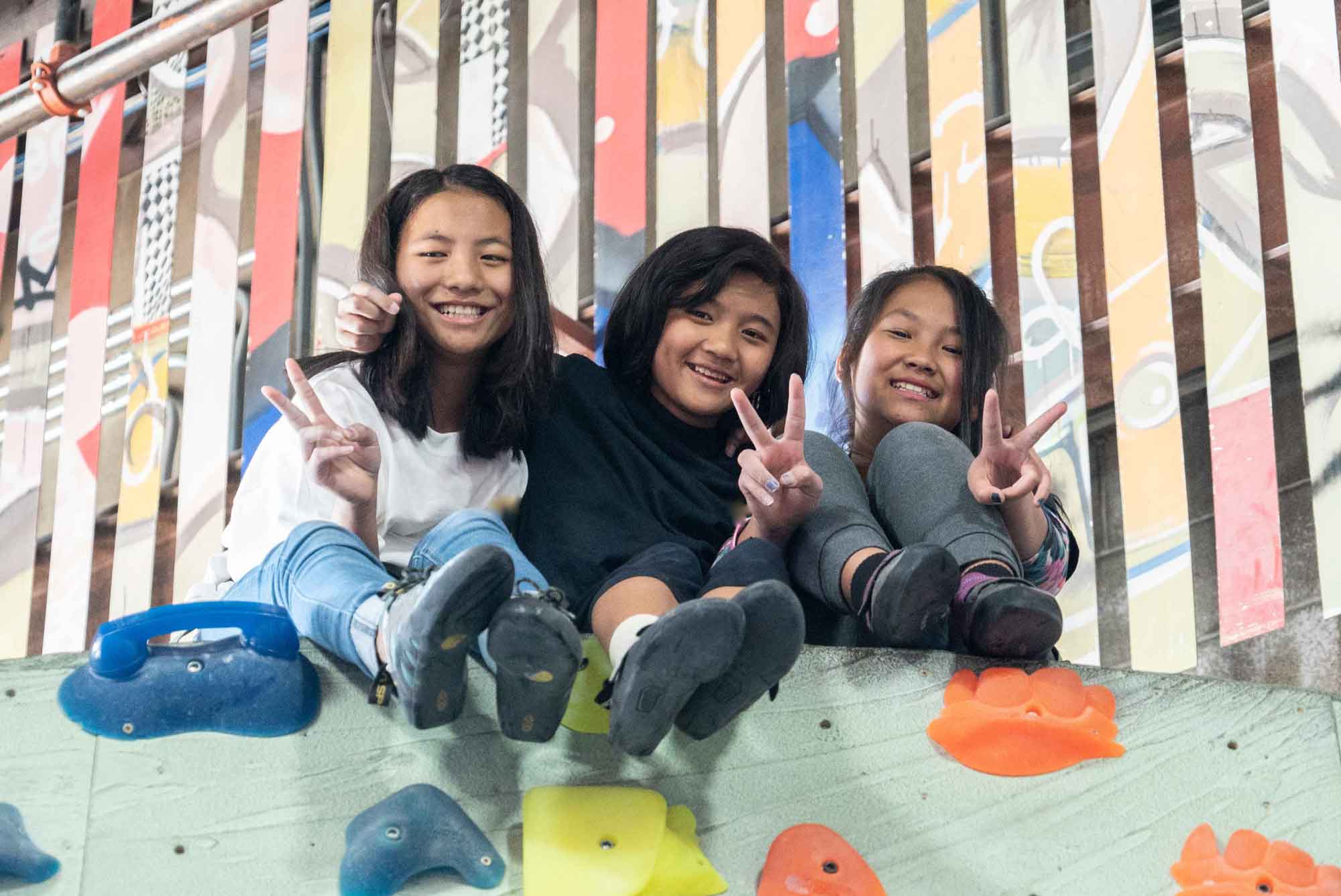 A group of young refugee women making peace signs