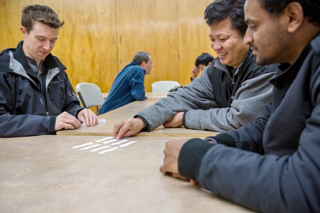 A group of refugees attending a class on digital technology at their local resettlement office